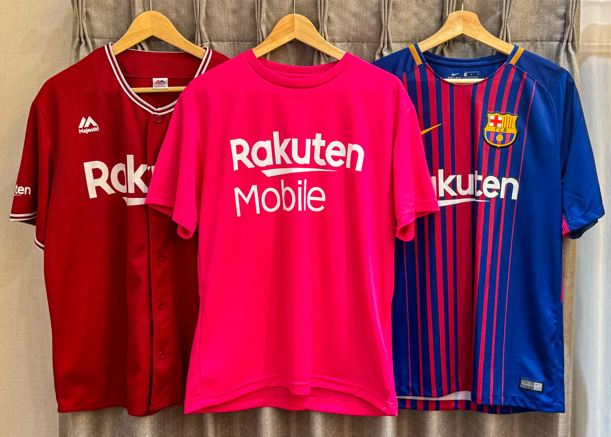 楽天モバイルのピンクTシャツと、Rakutenがスポンサーを務める野球・FCバルセロナのユニフォームが並ぶ画像