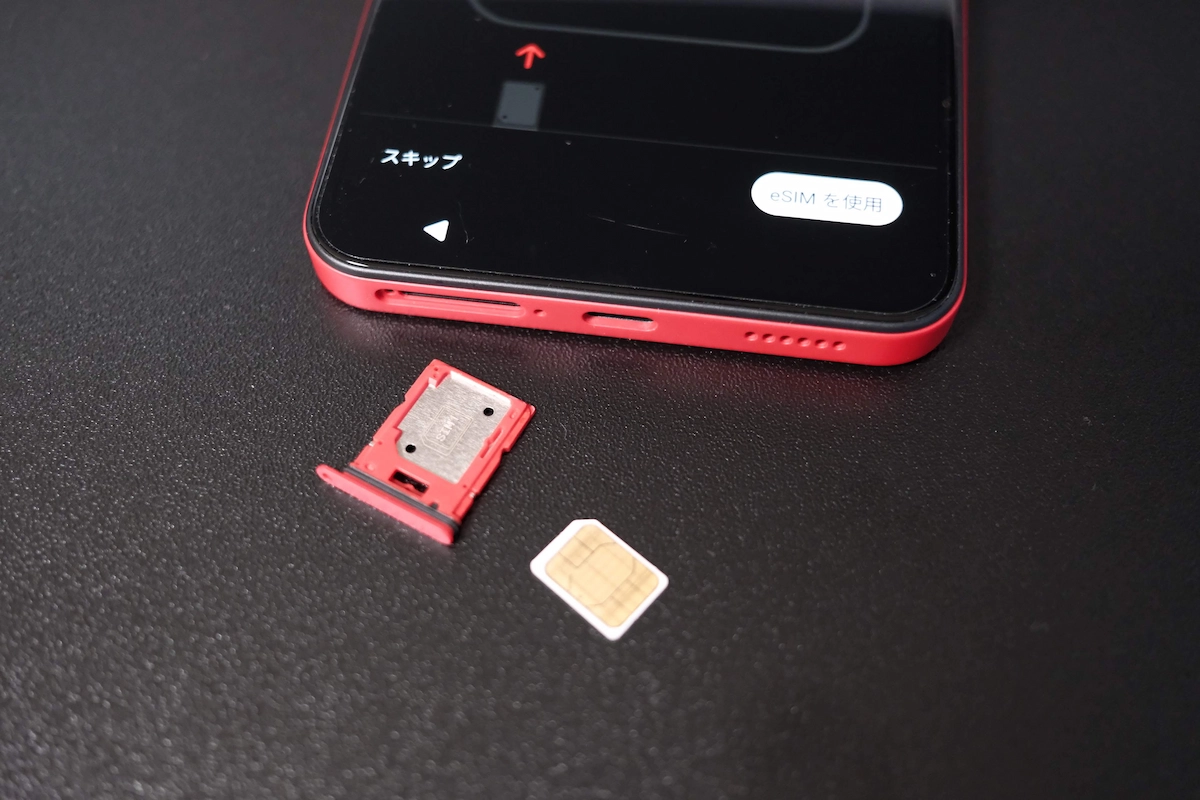 Nothing PhoneレッドのSIMトレイと物理SIMカードを並べた写真